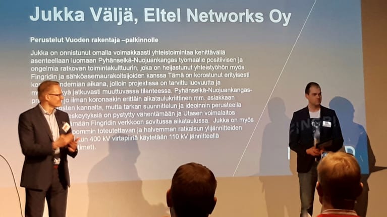 Eltelin Jukka Väljä vastaanottamassa Fingridin Vuoden rakentaja -palkintoa Timo Kiiveriltä Fingridin Kantaverkkopäivässä.